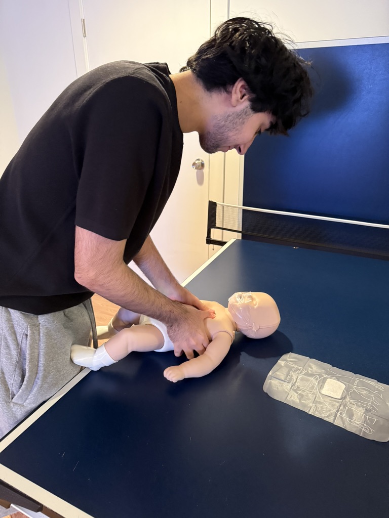 Instructor practicing infant CPR on a training manikin