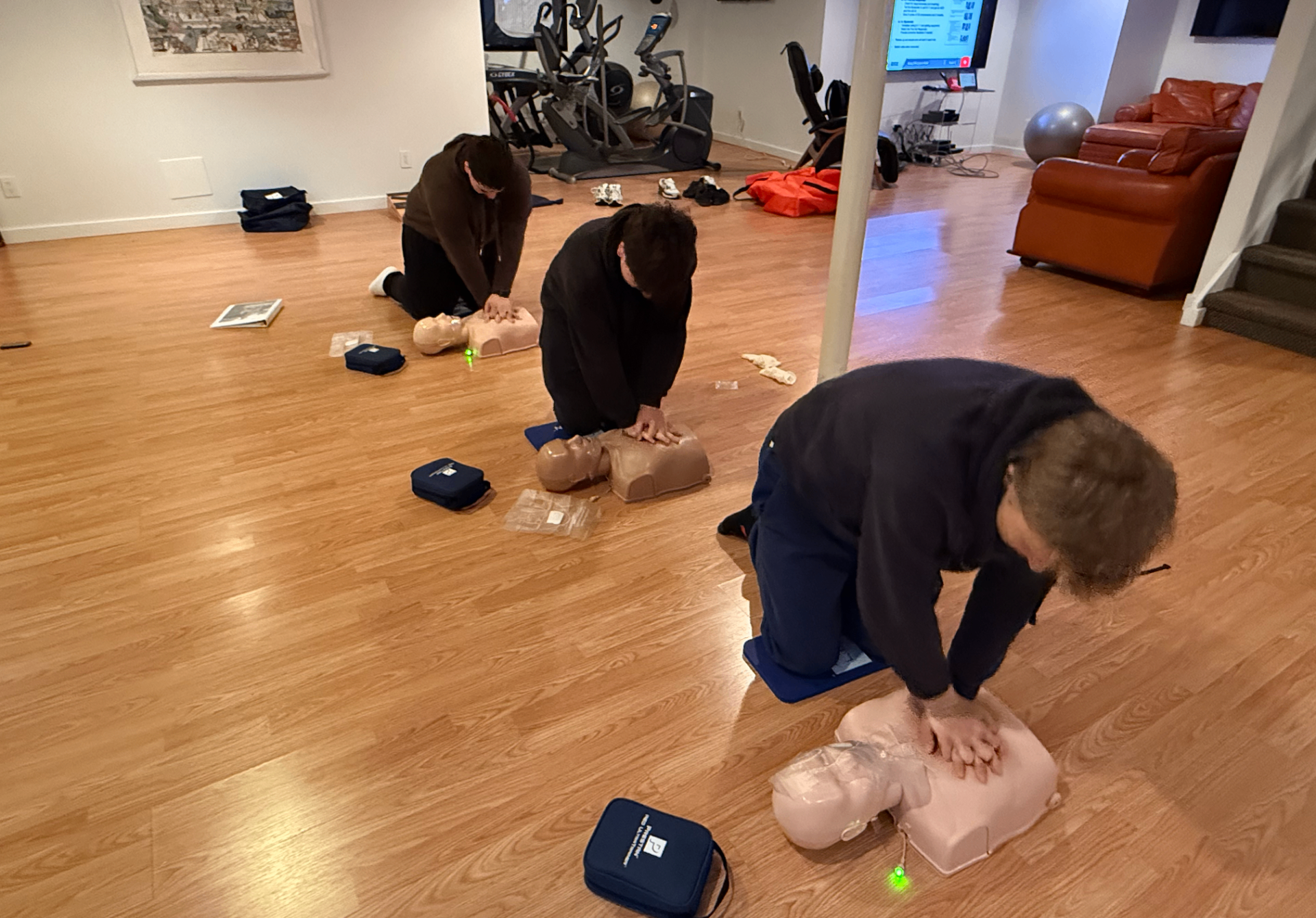 Adults practicing chest compressions on CPR manikins